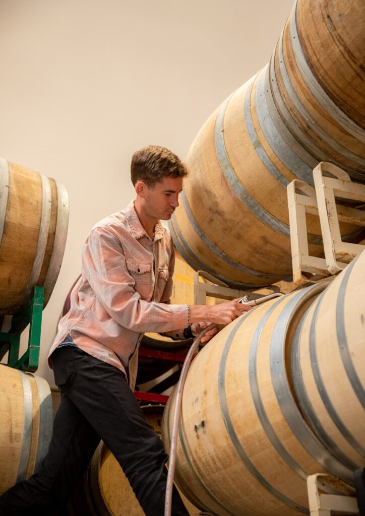 Neal Kennedy, SAMsARA Cellar Master, tops off barrels at the SAMsARA winery. 