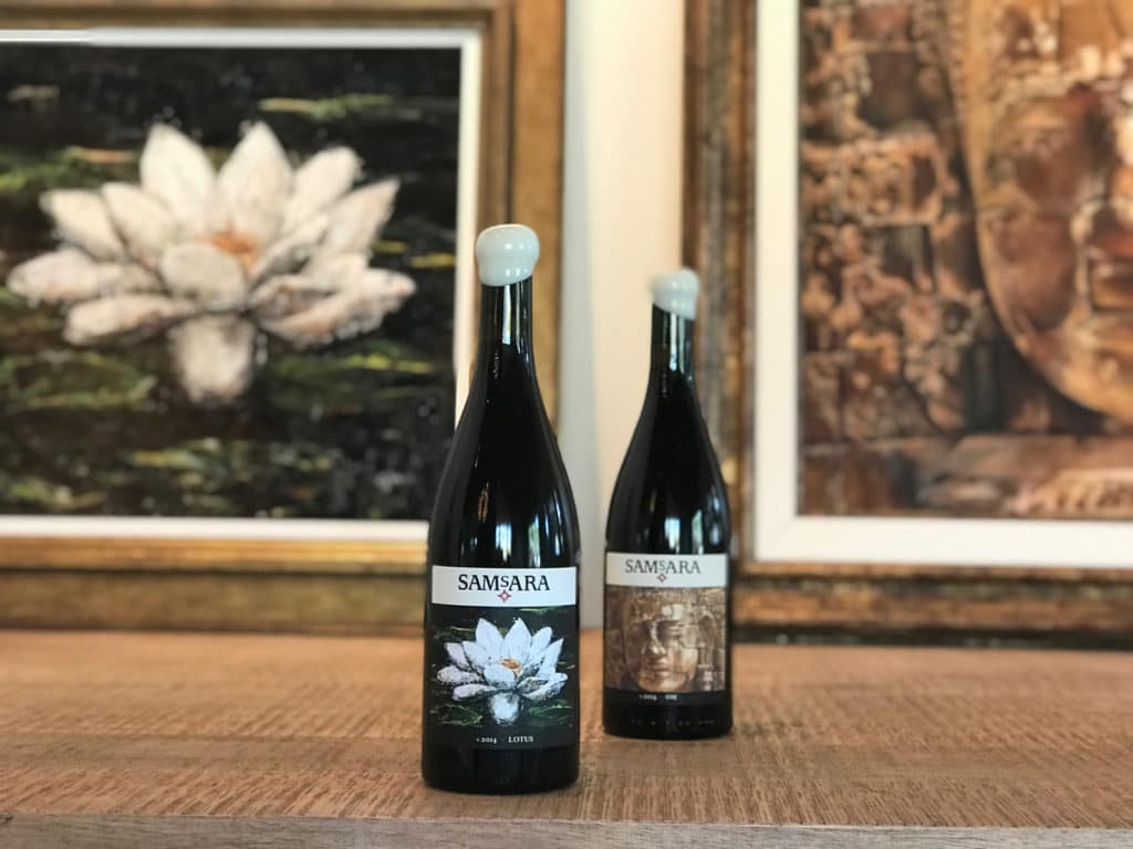 Gina Torkos designed the SAMsARA LOTUS and OM labels. Her original artwork, seen in the background, hangs at the winery’s tasting room.